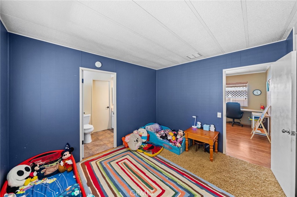 26311 Jackson Avenue, Unit 35 Murrieta, CA 92563 - Photo 18 of 41 a bedroom with a bed and wooden floor