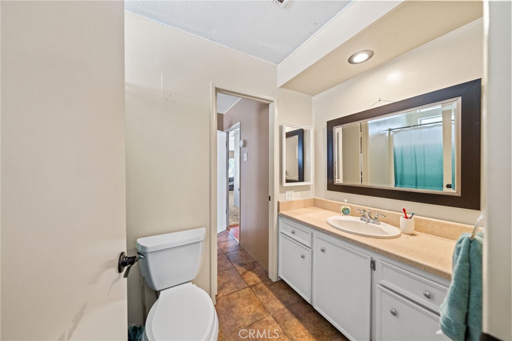 26311 Jackson Avenue, Unit 35 Murrieta, CA 92563 - Photo 22 of 41 a bathroom with a granite countertop toilet sink and mirror