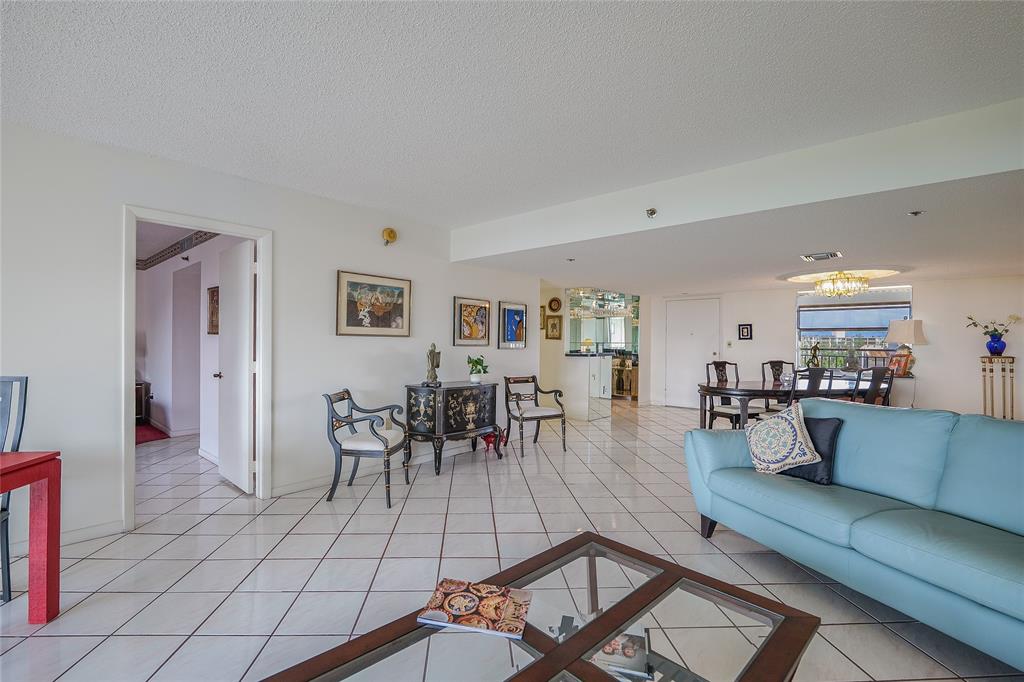 3910 Inverrary Boulevard, Unit 805B Lauderhill, FL 33319 - Photo 5 of 38 a living room with furniture and a dining table with kitchen view