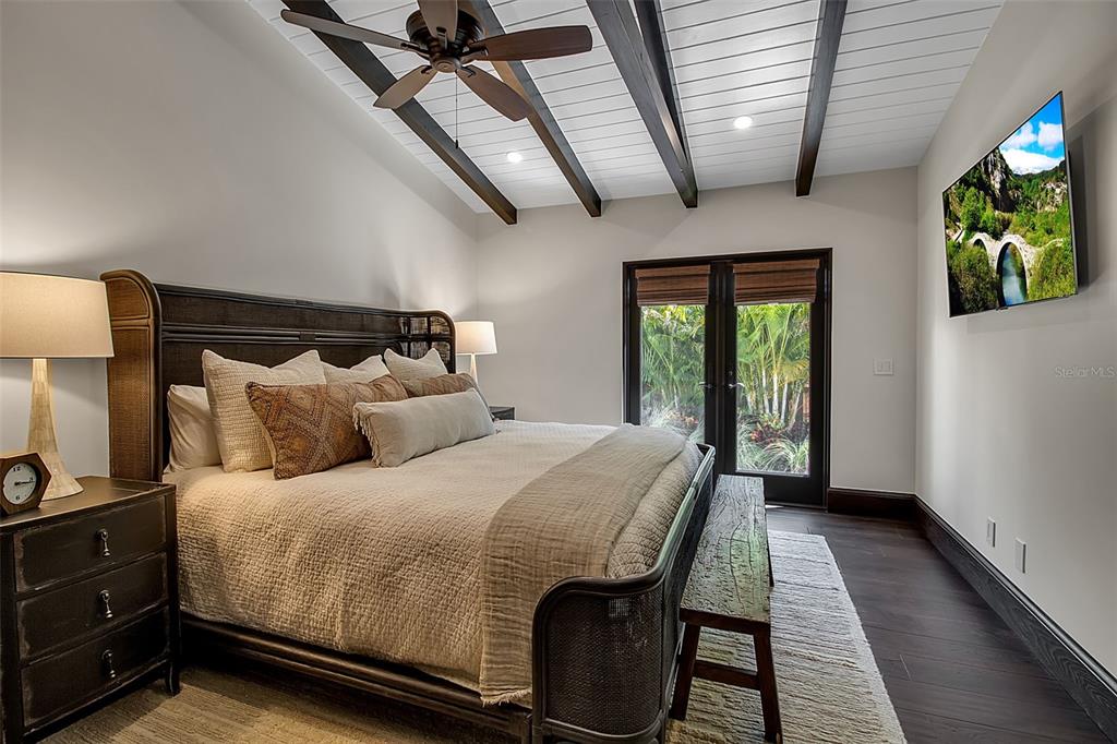 121 North Casey Key Road Osprey, FL 34229 - Photo 34 of 63 a bedroom with a large bed and a flat tv screen on dresser