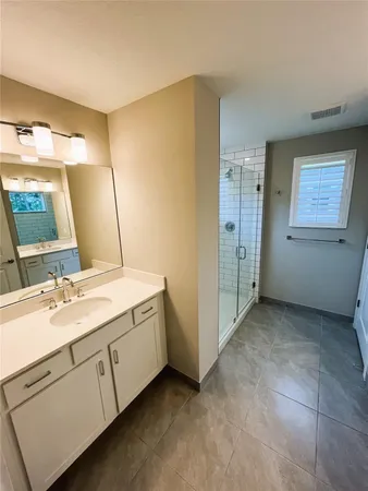 a spacious bathroom with a double vanity sink and a mirror