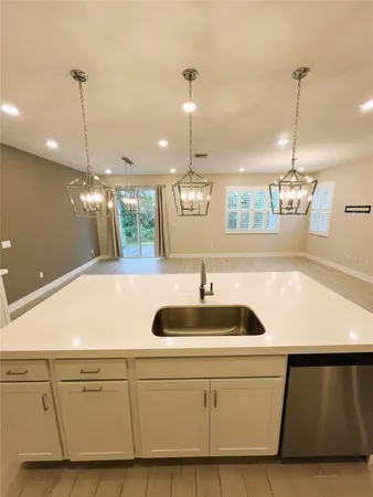 a kitchen with a sink chandelier and refrigerator
