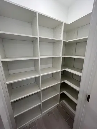 a view of walk in closet with empty racks
