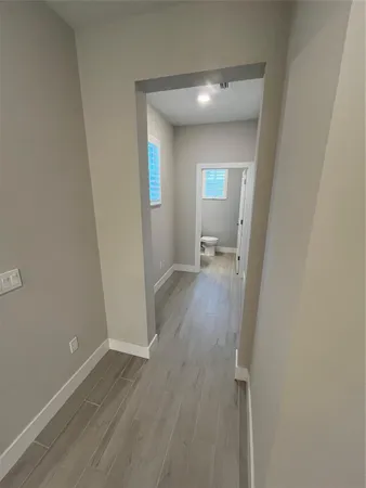 a view of a room with wooden floor and a bathroom