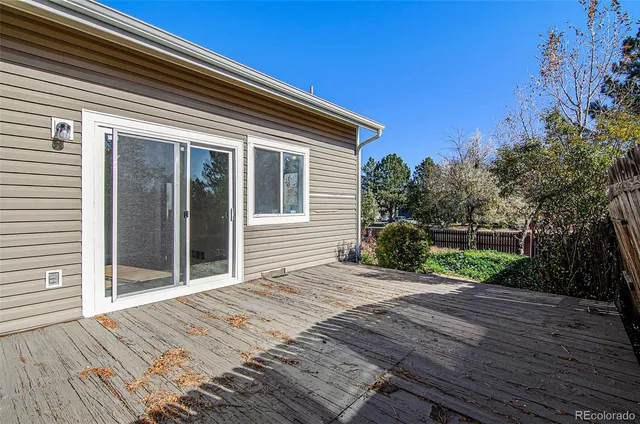 a view of house with backyard and wooden fence