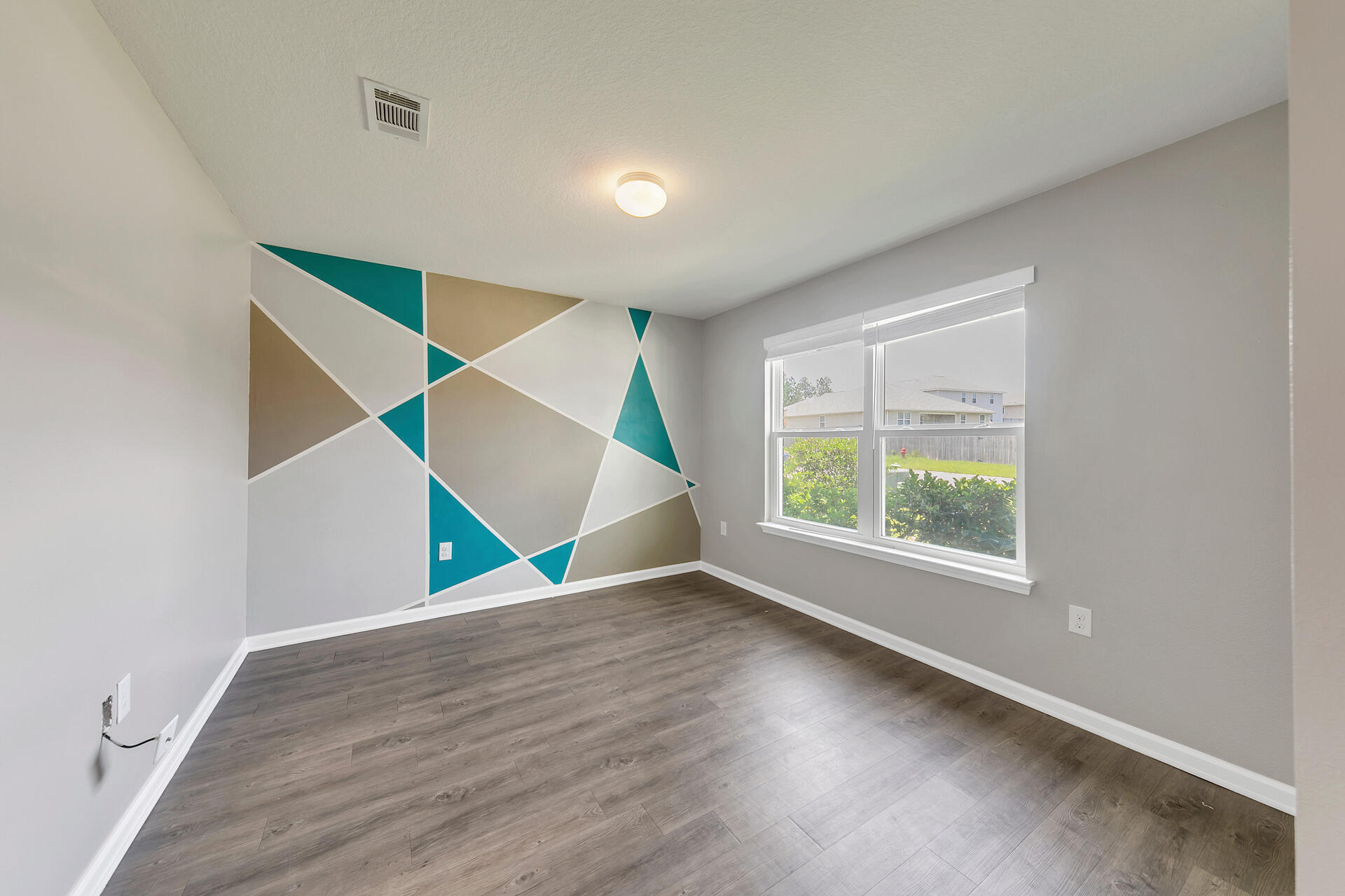 4624 Plover Drive Crestview, FL 32539 - Photo 13 of 34 an empty room with wooden floor and windows