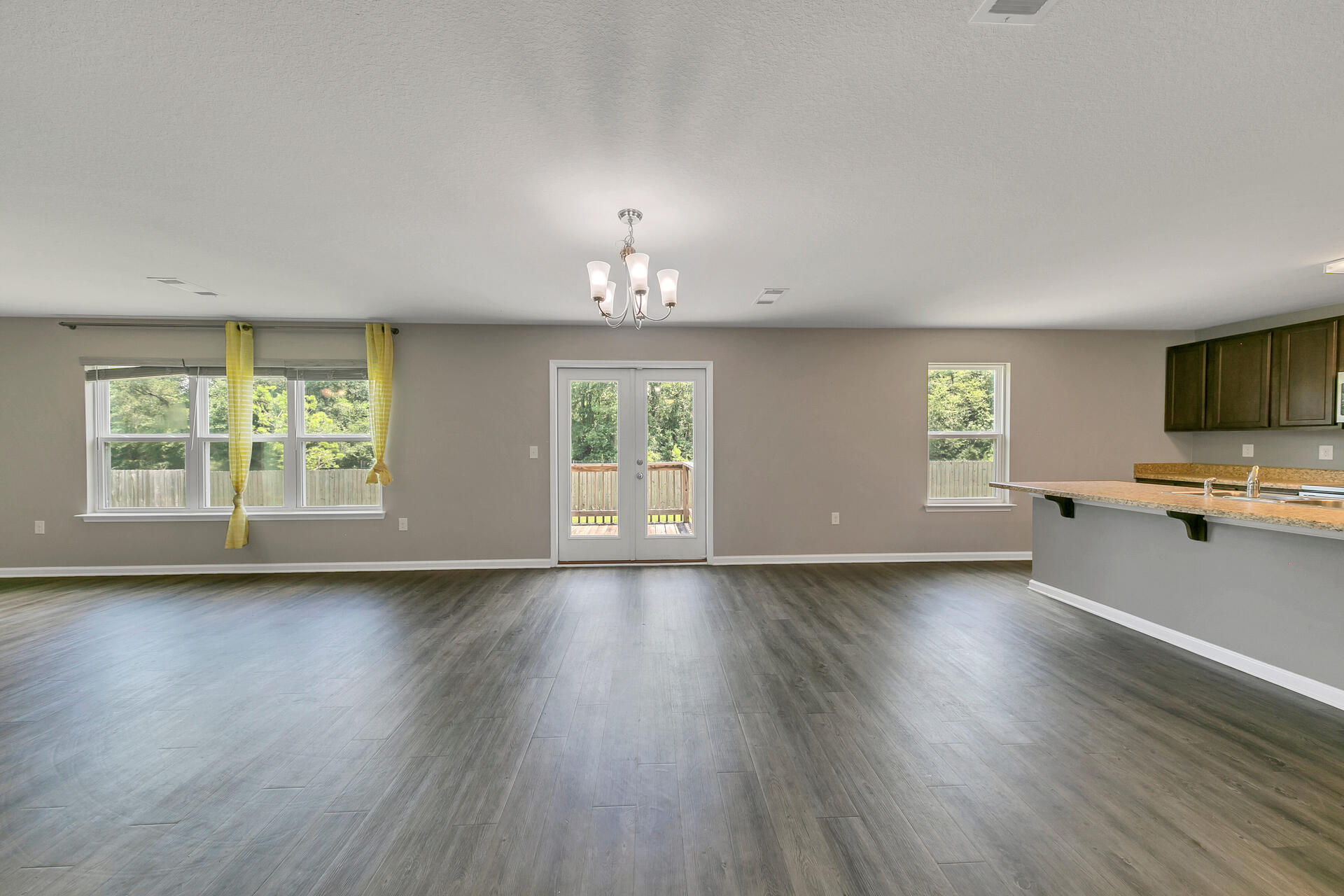 4624 Plover Drive Crestview, FL 32539 - Photo 6 of 34 a view of an empty room with a window and wooden floor