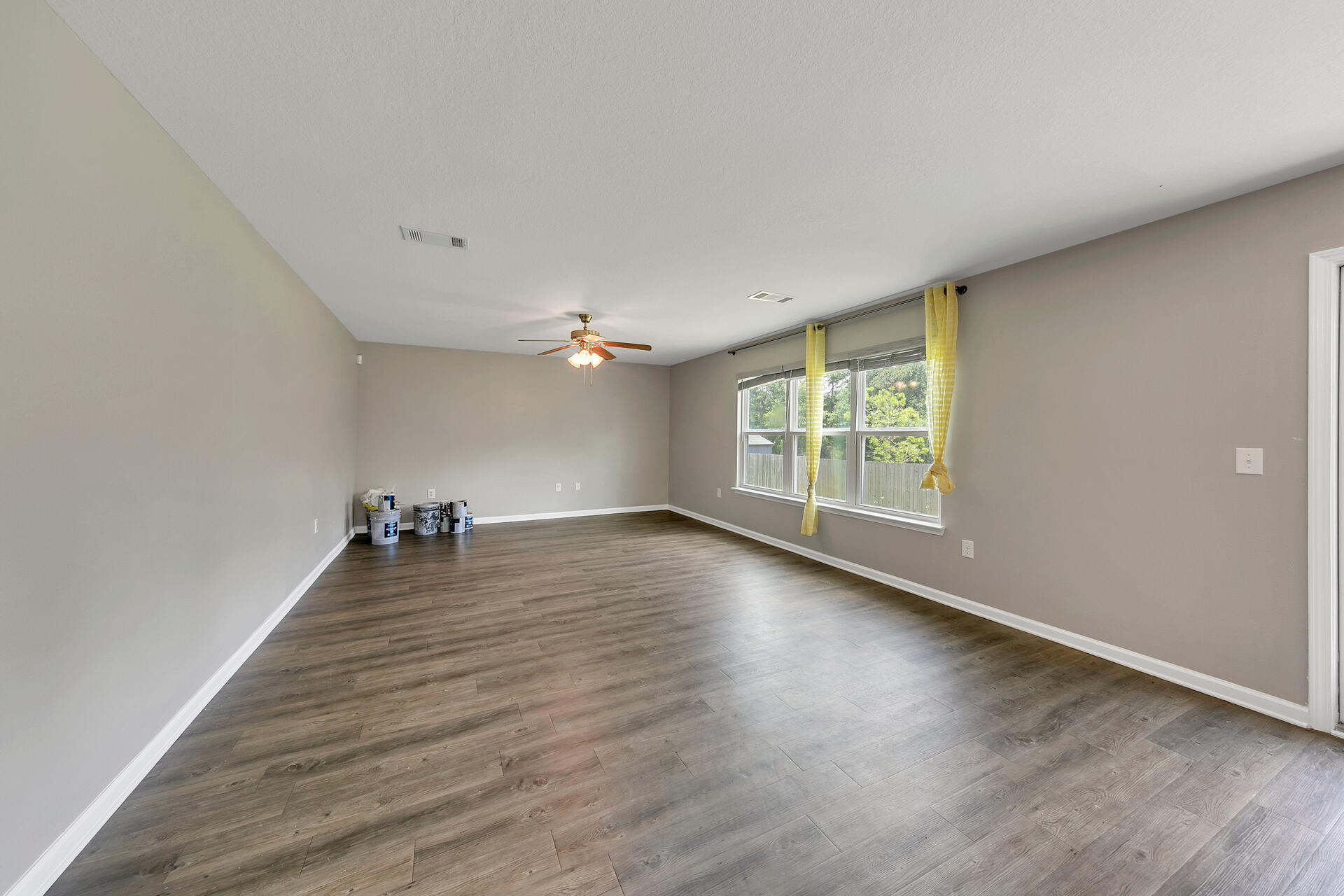 4624 Plover Drive Crestview, FL 32539 - Photo 8 of 34 an empty room with wooden floor and windows