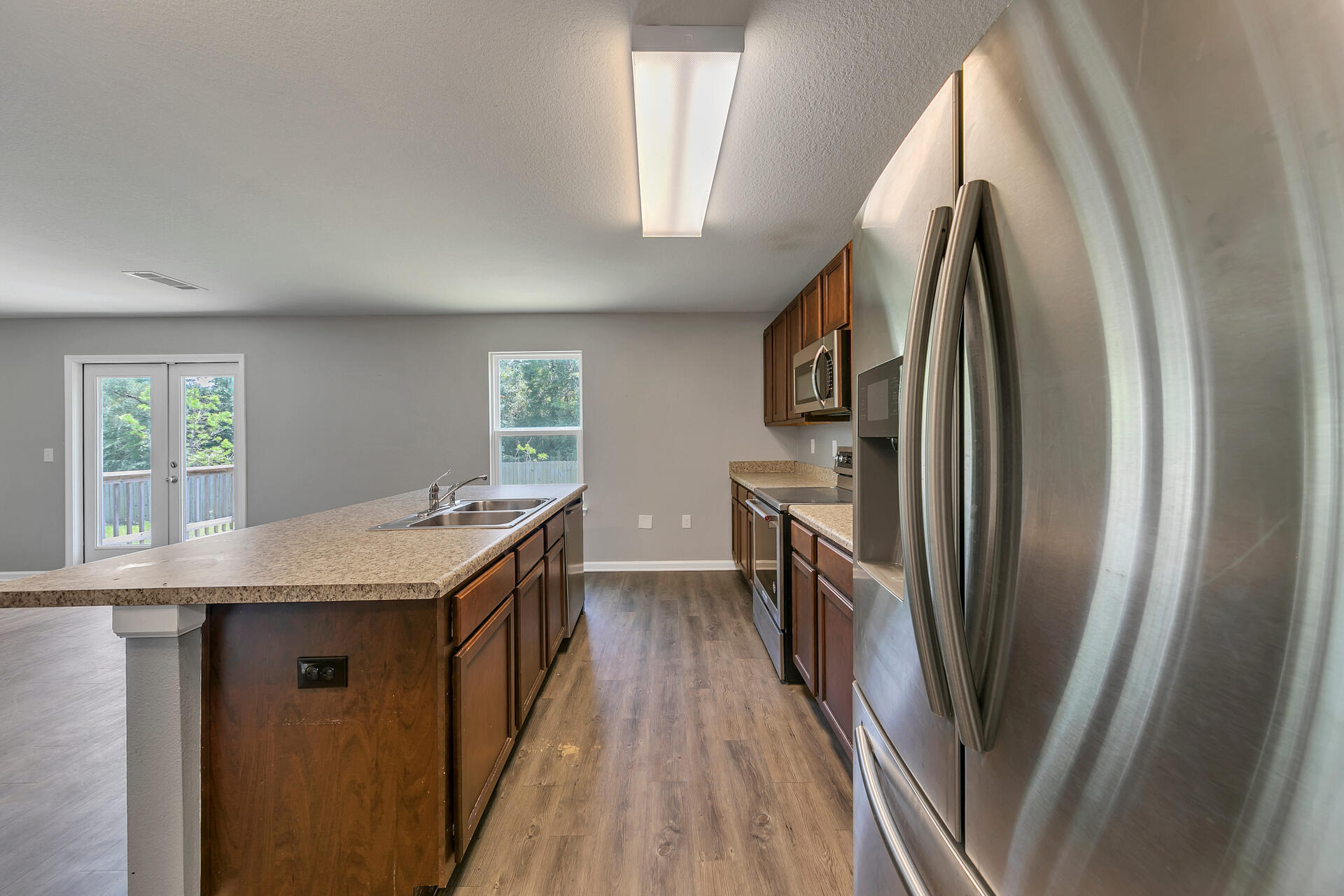 4624 Plover Drive Crestview, FL 32539 - Photo 10 of 34 a kitchen with stainless steel appliances granite countertop a refrigerator a stove a sink and a window