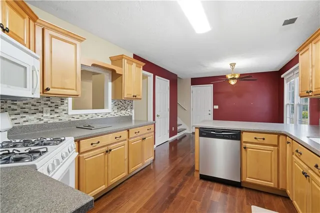 a kitchen with stainless steel appliances granite countertop a sink and wooden cabinets