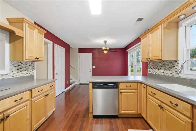 a kitchen with white cabinets and sink