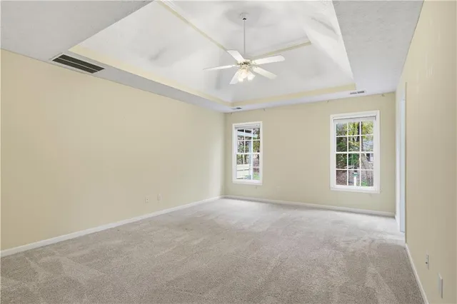 an empty room with a window and ceiling fan