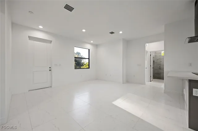 an empty room with windows and mirror