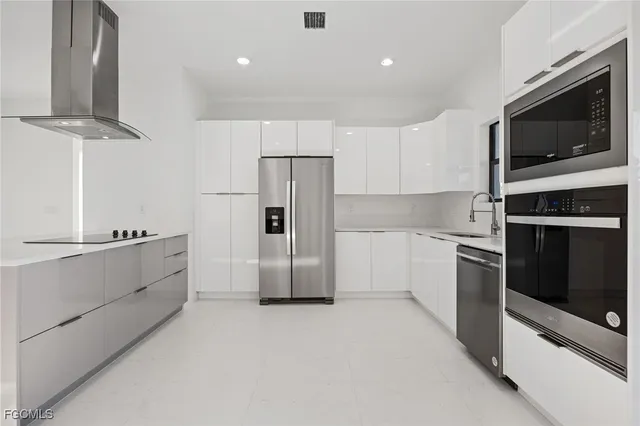 a kitchen with stainless steel appliances a refrigerator stove and microwave