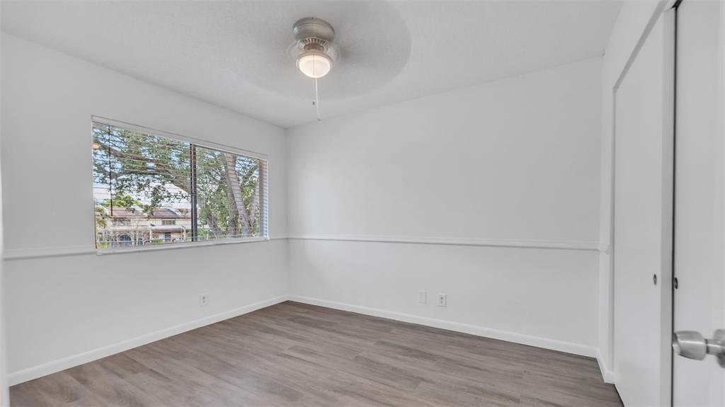 1153 Hampton Boulevard North Lauderdale, FL 33068 - Photo 6 of 10 an empty room with wooden floor and windows