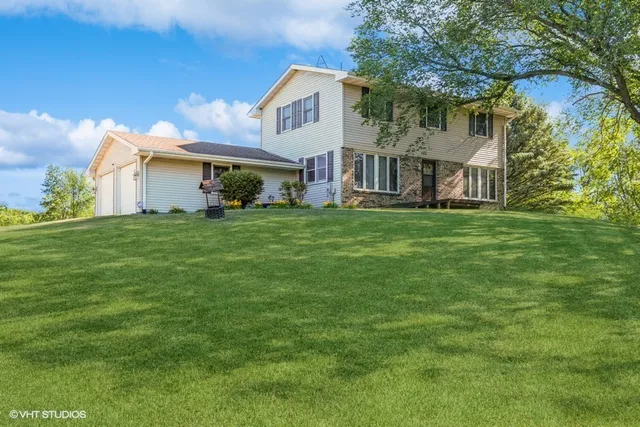 a view of a big house with a big yard and large trees