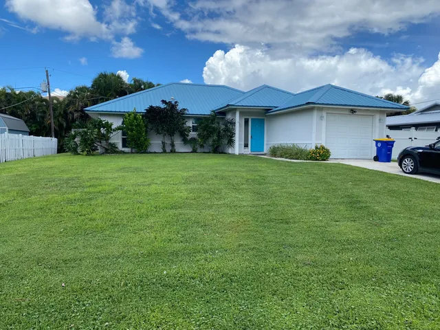 a view of a house with a yard and sitting area