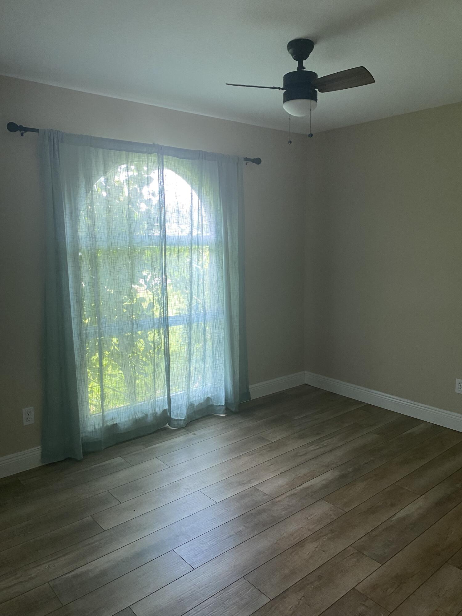 3196 Southwest Areca Drive Palm City, FL 34990 - Photo 17 of 21 an empty room with wooden floor fan and windows