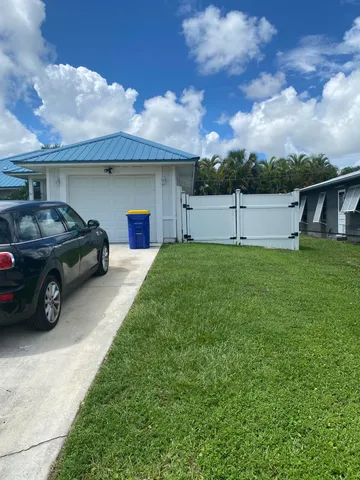 a view of a car in front of a house with a yard