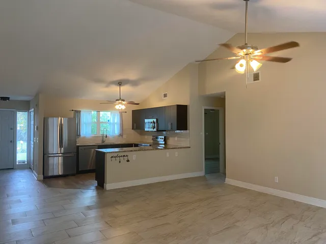 a kitchen with stainless steel appliances a stove a refrigerator and chandelier
