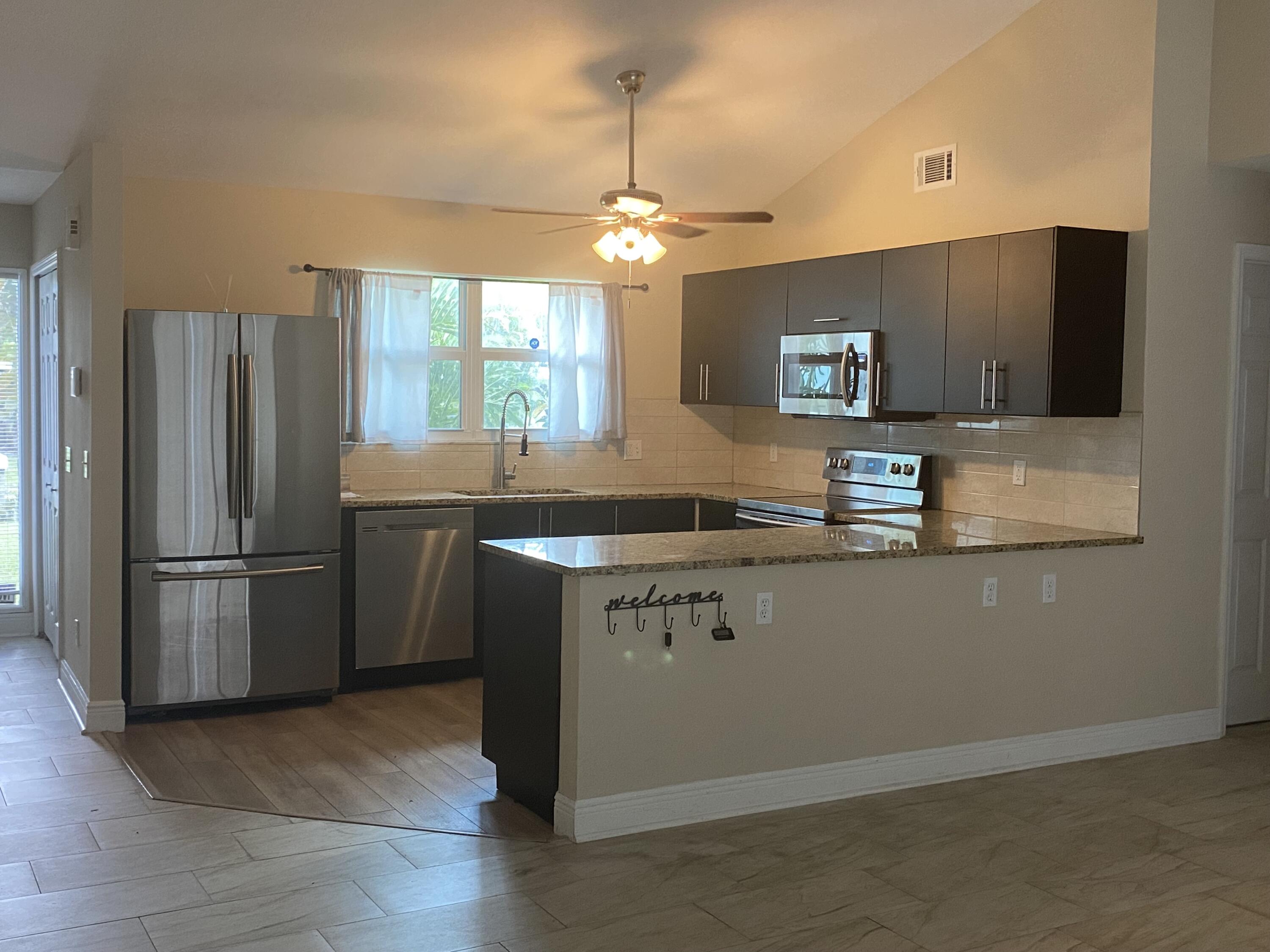3196 Southwest Areca Drive Palm City, FL 34990 - Photo 10 of 21 a kitchen with stainless steel appliances granite countertop a refrigerator a sink dishwasher a stove and a refrigerator