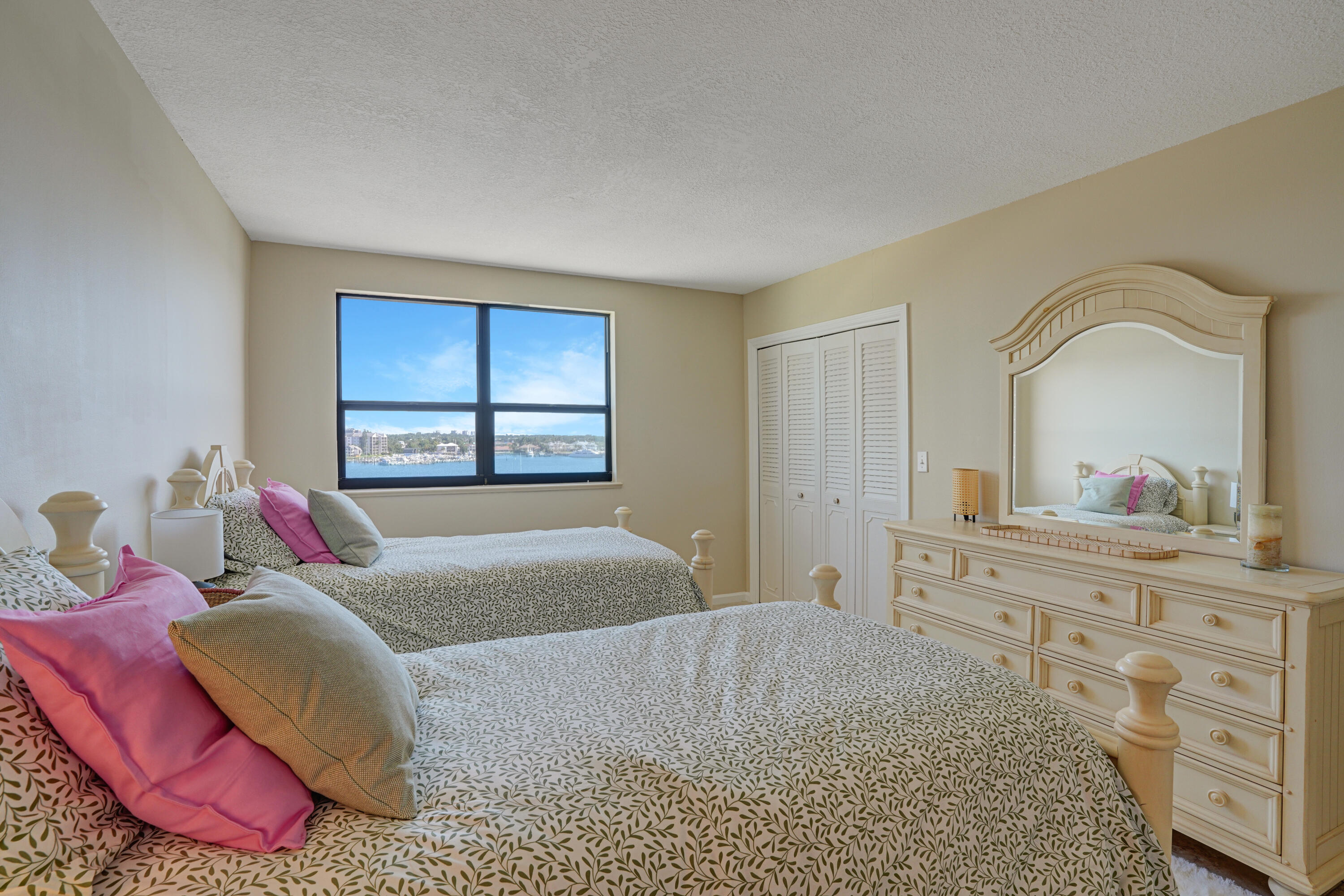 1208 Marine Way, Unit 602 North Palm Beach, FL 33408 - Photo 18 of 25 a bedroom with a bed and a dresser with mirror