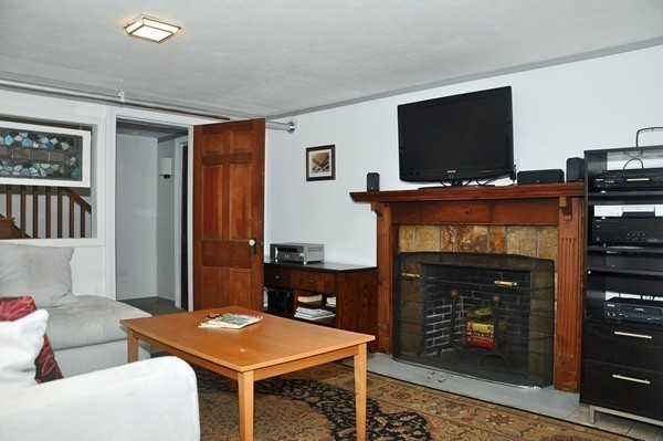 1188 Brook Road Milton, MA 02186 - Photo 11 of 12 a living room with furniture a flat screen tv and a fireplace