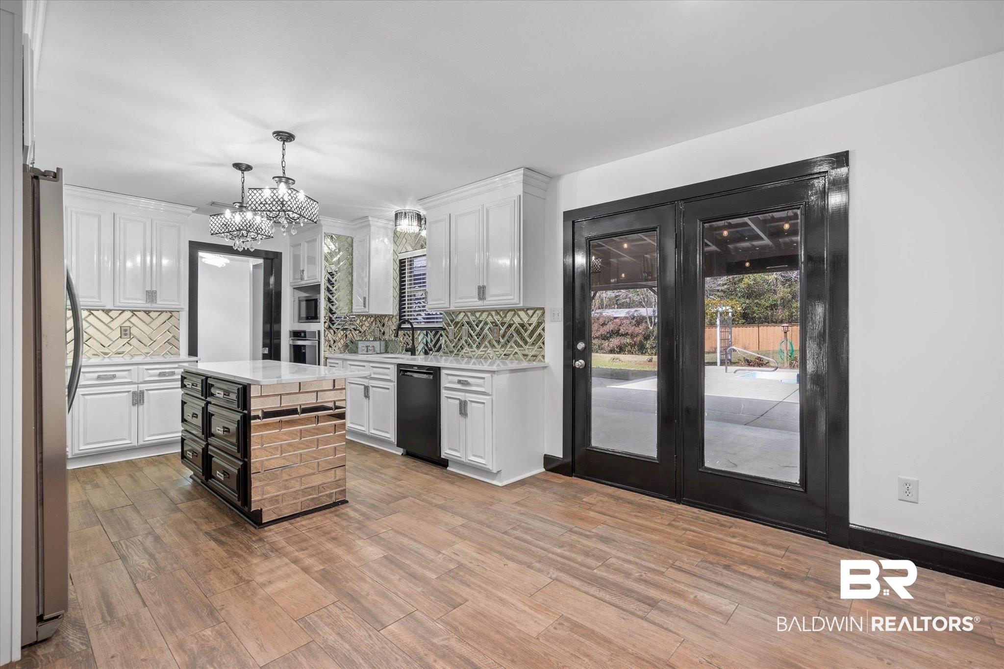 3216 Bay Booster Club Road Theodore, AL 36582 - Photo 5 of 46 Kitchen featuring dual tone cabinets, decorative backsplash, stainless steel appliances, light wood-style floors, and a kitchen island