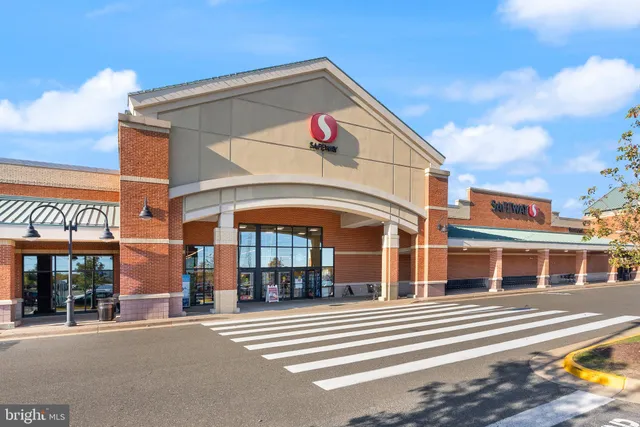 a man walking down a street next to a building