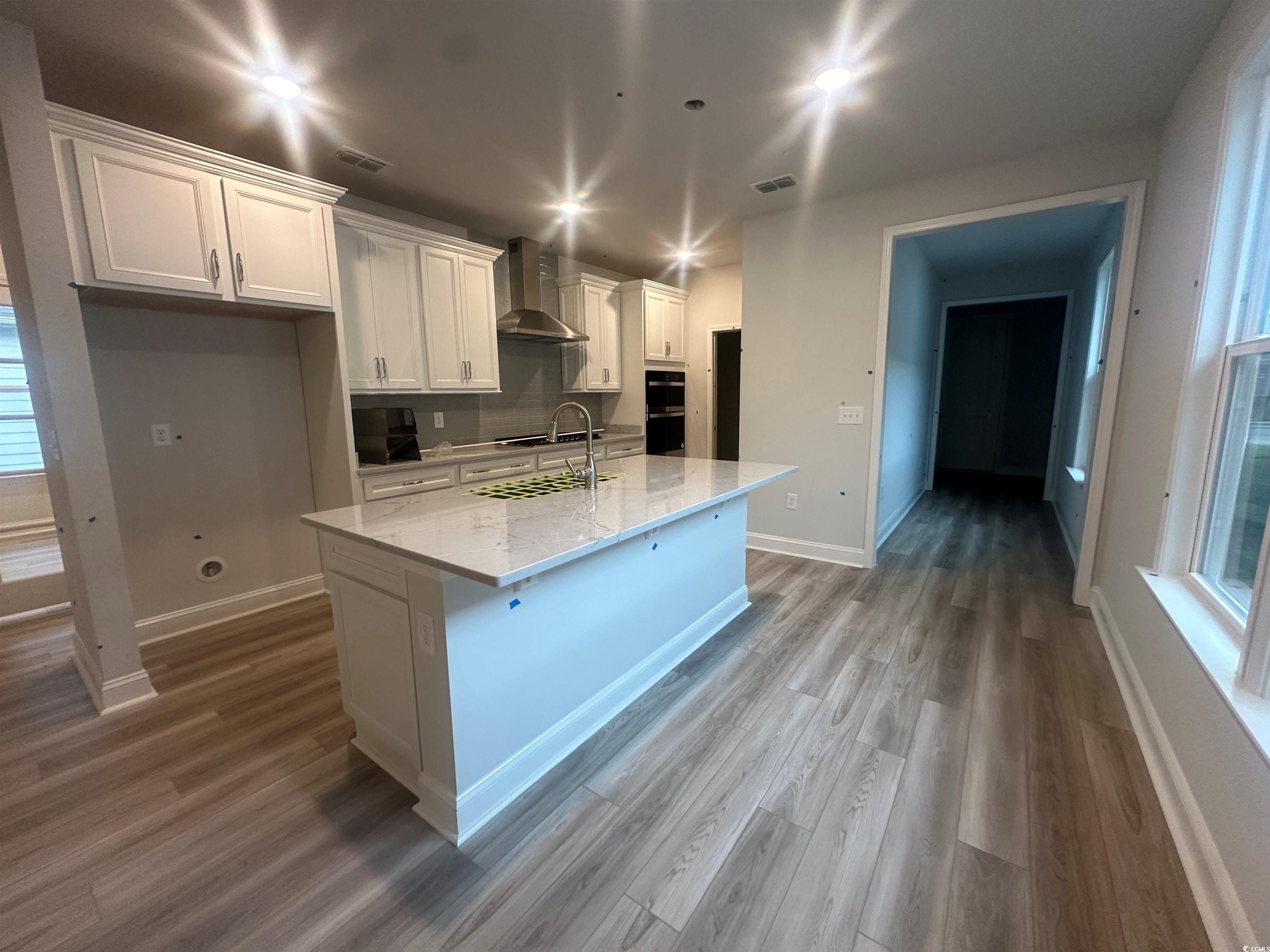 1541 Littleleaf Loop North Myrtle Beach, SC 29582 - Photo 4 of 19 Kitchen featuring white cabinets, an island with s