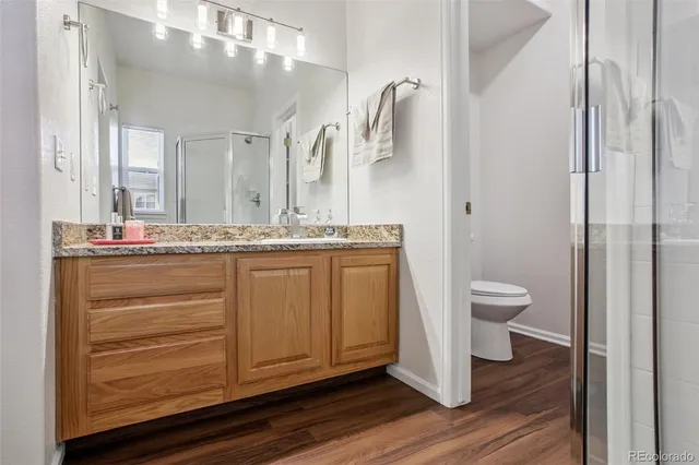 a bathroom with a granite countertop sink toilet and shower