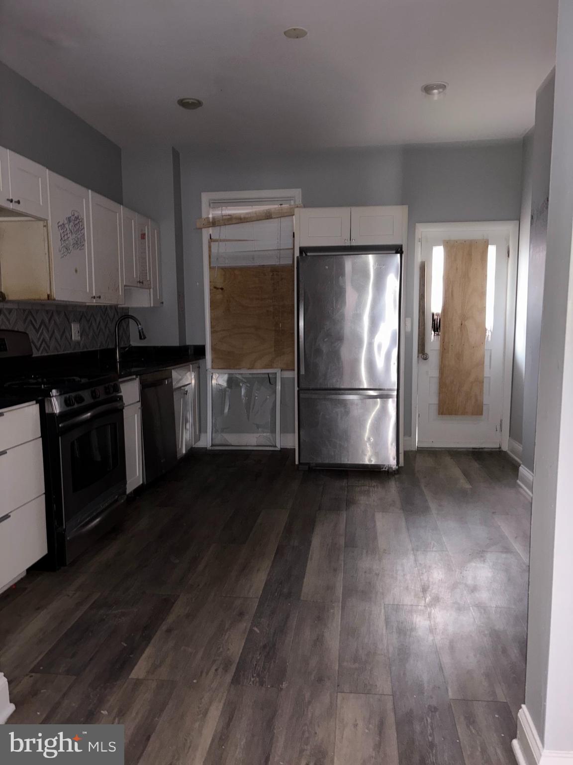 3413 Noble Street Baltimore, MD 21224 - Photo 21 of 43 a kitchen with stainless steel appliances granite countertop a refrigerator a stove and a wooden floors