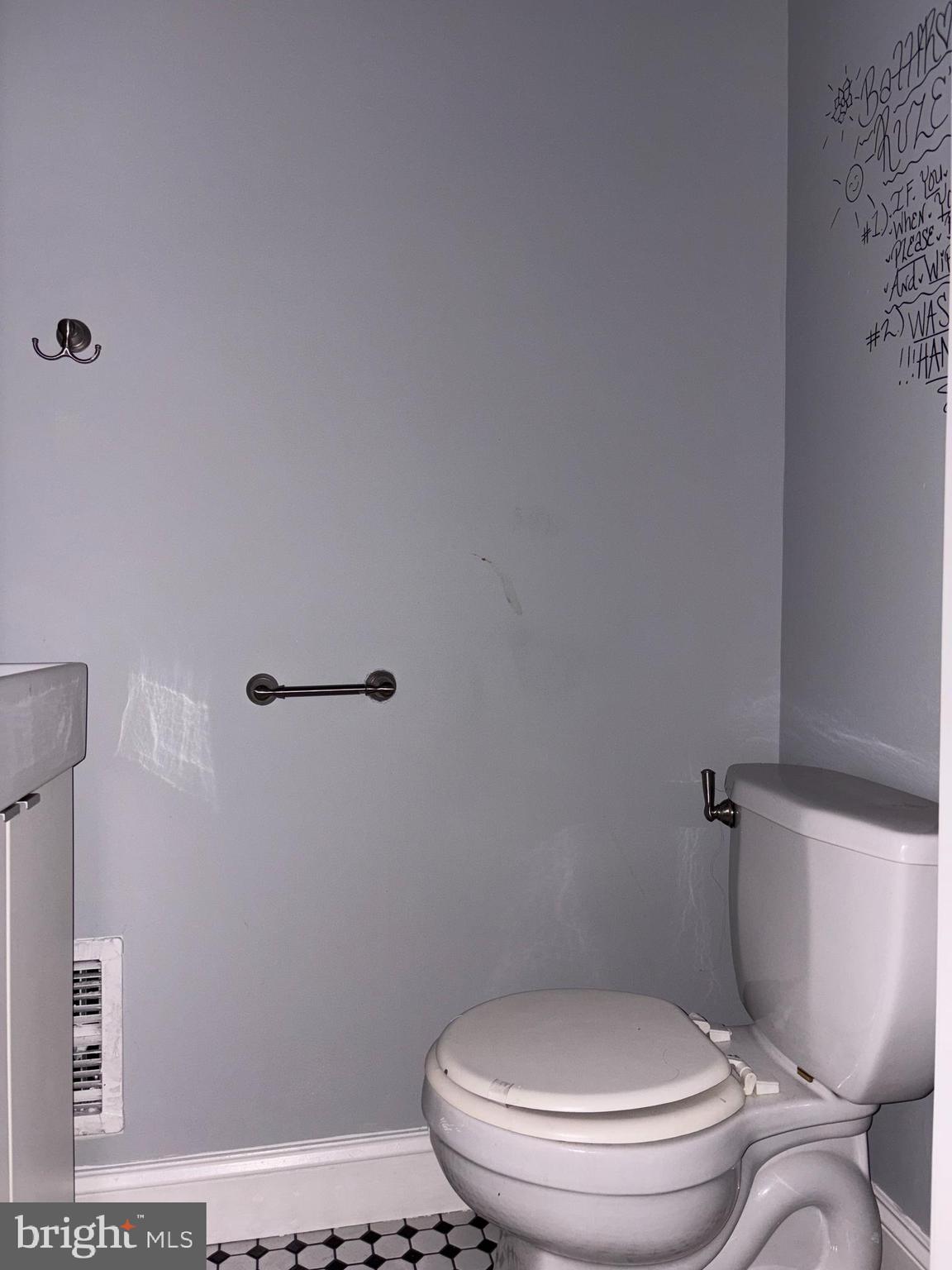 3413 Noble Street Baltimore, MD 21224 - Photo 6 of 43 a white toilet sitting next to a bathroom sink and a mirror