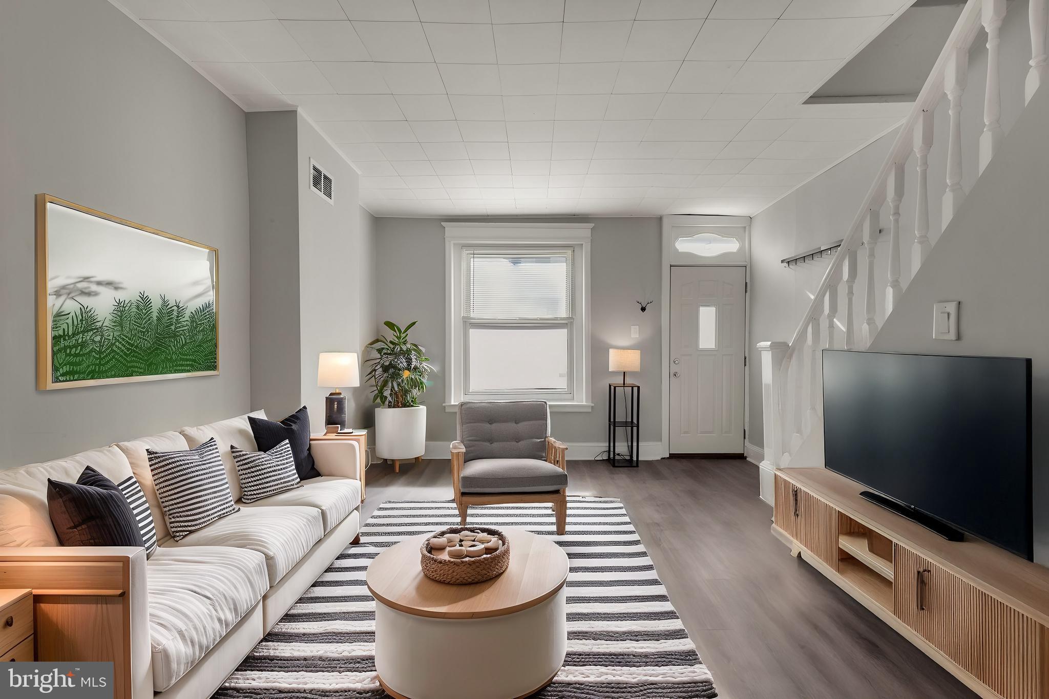 a living room with furniture a flat screen tv and a large window