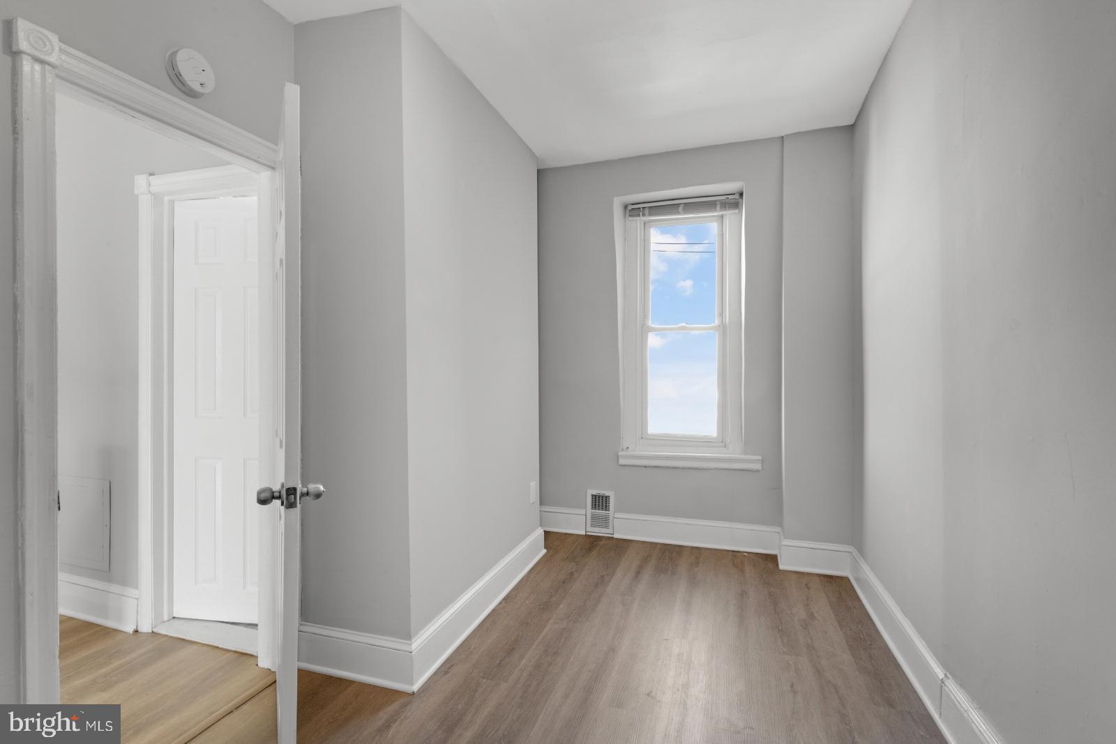 103 Daly Street Philadelphia, PA 19148 - Photo 20 of 23 an empty room with wooden floor and a window