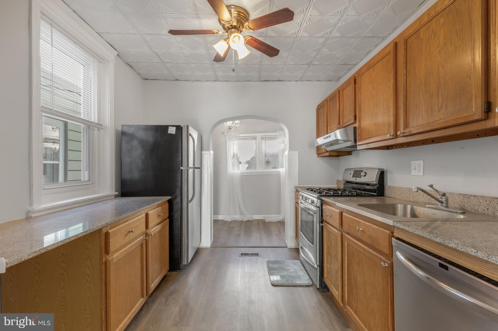 103 Daly Street Philadelphia, PA 19148 - Photo 3 of 23 a kitchen with stainless steel appliances granite countertop a refrigerator a sink dishwasher a stove and white countertops with wooden floor