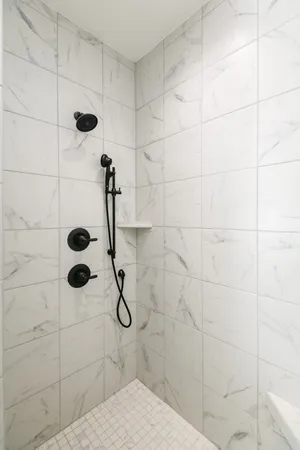 a bathroom with a tub a window and a shower