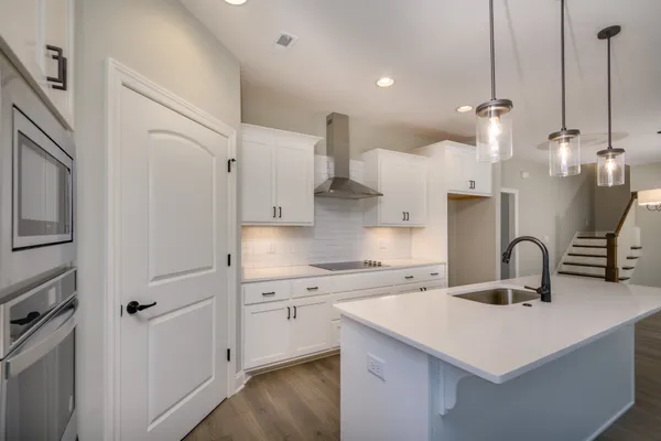 a kitchen with granite countertop a sink and white cabinets