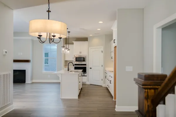 a view of kitchen with stainless steel appliances granite countertop a stove a refrigerator and a sink with wooden floor