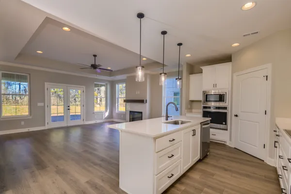 a large kitchen with stainless steel appliances kitchen island a large counter top and a stove top oven