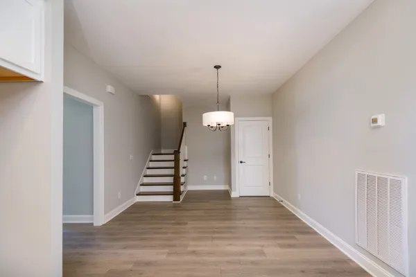a view of a kitchen with furniture a ceiling fan and wooden floor