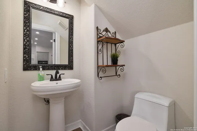 a bathroom with a toilet sink and mirror