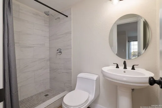 a bathroom with a toilet sink and shower