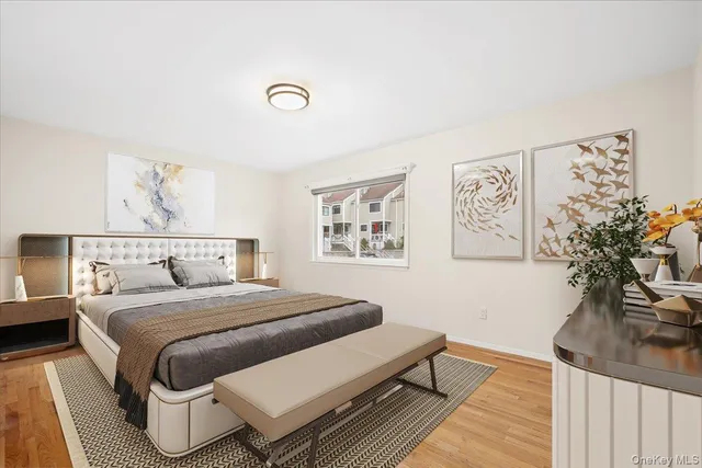 a bedroom with a bed and a potted plant on dresser