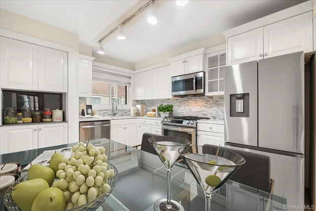 a kitchen with white cabinets and stainless steel appliances