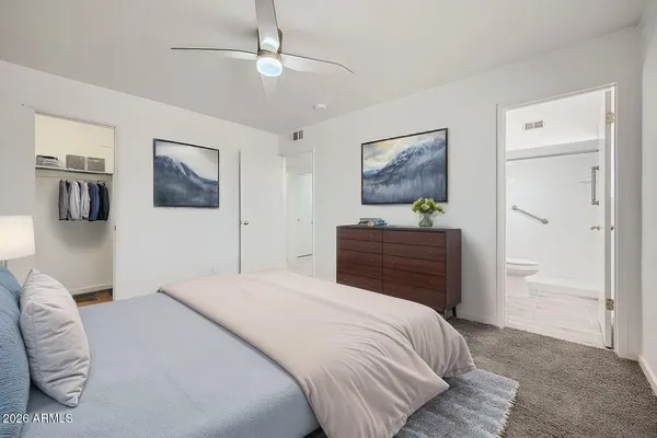 a bedroom with a bed and a painting on the wall