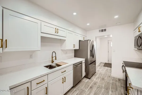 a kitchen with stainless steel appliances a refrigerator sink and cabinets