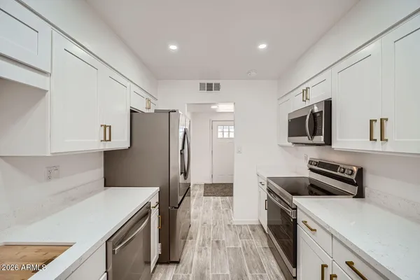 a kitchen with stainless steel appliances a refrigerator stove microwave and sink