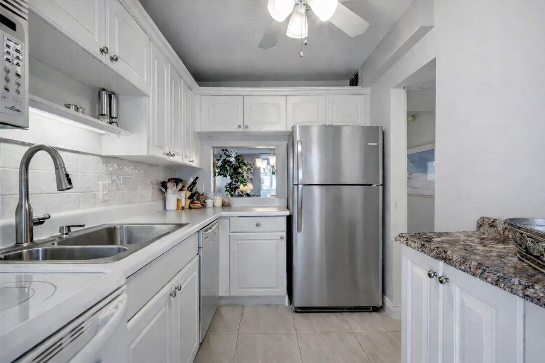 4500 North Federal Highway, Unit 121C Lighthouse Point, FL 33064 - Photo 6 of 14 a kitchen with refrigerator and cabinets