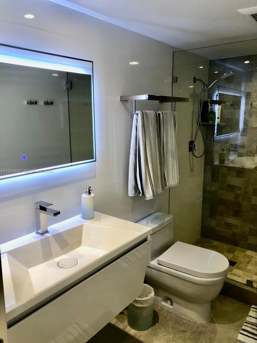 8877 Collins Avenue, Unit 308 Surfside, FL 33154 - Photo 13 of 22 a bathroom with a sink a toilet and shower